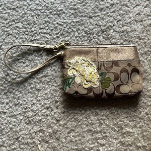 Coach wristlet with gold and flower accent